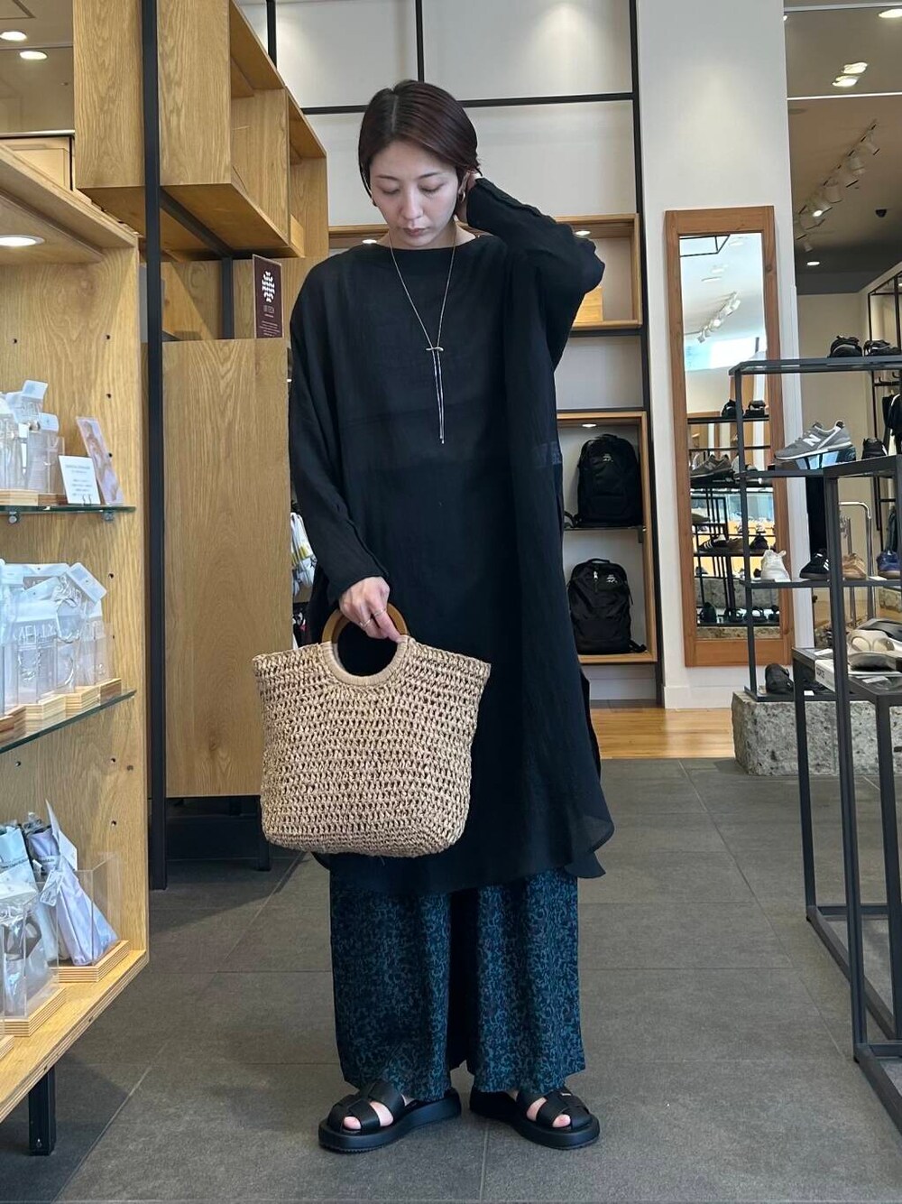 ベージュ系のタンクトップ、ベージュ系のトートバッグ、ブラック系のサンダルを着用したレディースの春コーディネートの4枚目の写真