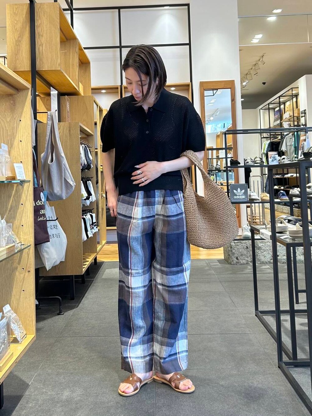 イエロー系のトートバッグ、ブルー系のその他パンツ、ブラウン系のサンダルを着用したレディースの春コーディネートの2枚目の写真