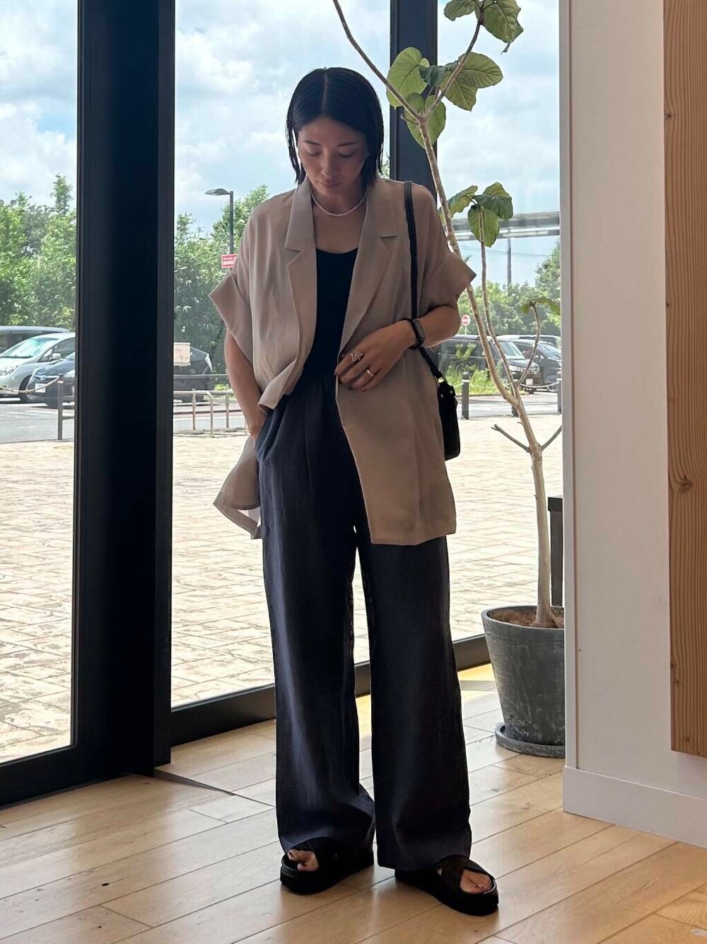 ブラック系のショルダーバッグ、ブラウン系のサンダル、ブルー系のその他パンツを着用したレディースの夏コーディネートの2枚目の写真