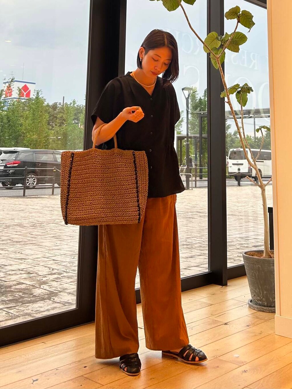 ベージュ系のトートバッグ、ベージュ系のタンクトップ、ブラック系のサンダルを着用したレディースの夏コーディネートの5枚目の写真