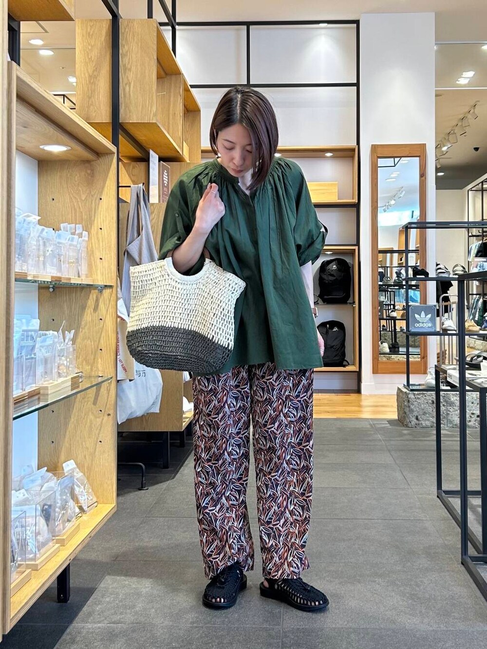 ベージュ系のトートバッグ、グリーン系のシャツ/ブラウス、ブルー系のその他パンツを着用したレディースの夏コーディネートの2枚目の写真