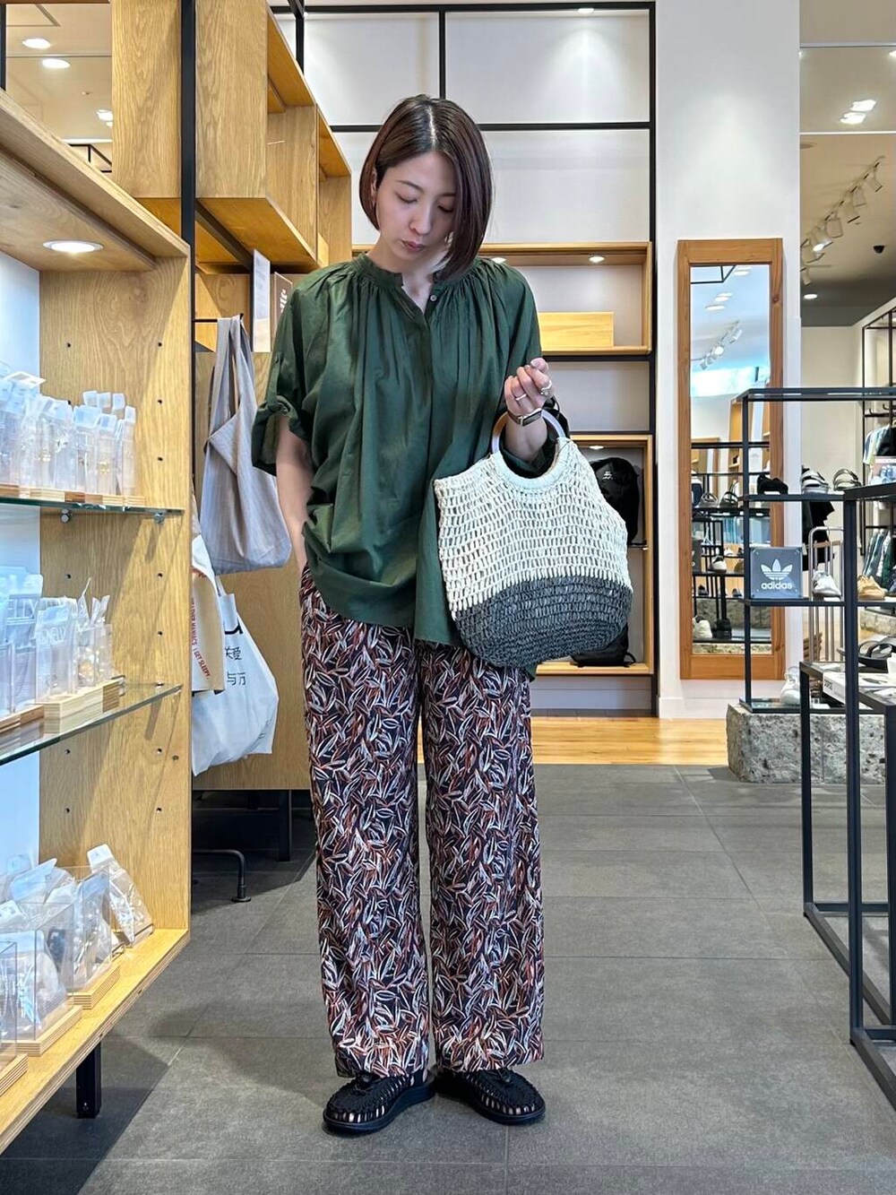 ベージュ系のトートバッグ、グリーン系のシャツ/ブラウス、ブルー系のその他パンツを着用したレディースの夏コーディネートの3枚目の写真