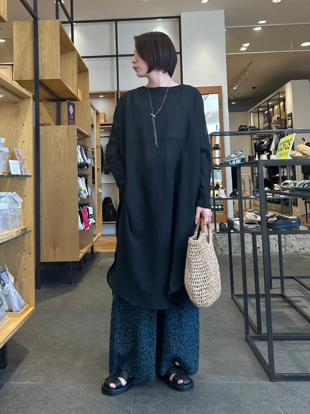 ベージュ系のタンクトップ、ベージュ系のトートバッグ、ブラック系のサンダルを着用したレディースの春コーディネートの2枚目の写真