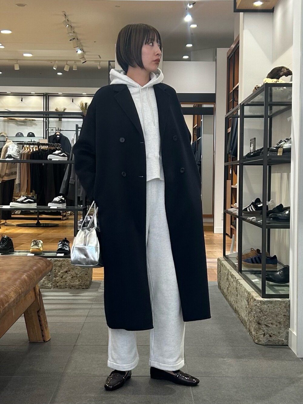 ベージュ系のパーカー、ブラウン系のローファー、シルバー系のボストンバッグを着用したレディースの冬コーディネートの4枚目の写真