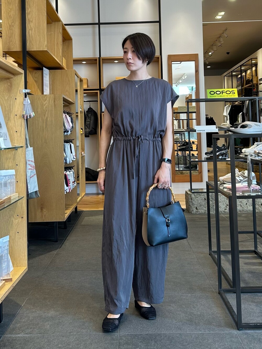 グレー系のサロペット/オーバーオール、ブラック系のハンドバッグ、ブラック系のバレエシューズを着用したレディースの夏コーディネートの2枚目の写真