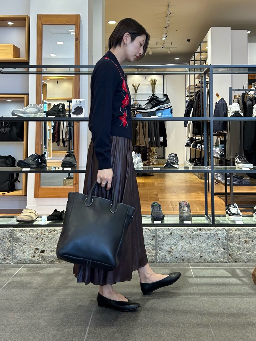 ブラウン系のスカート、ブルー系のニット/セーター、ブラック系のトートバッグを着用したレディースの秋コーディネートの2枚目の写真