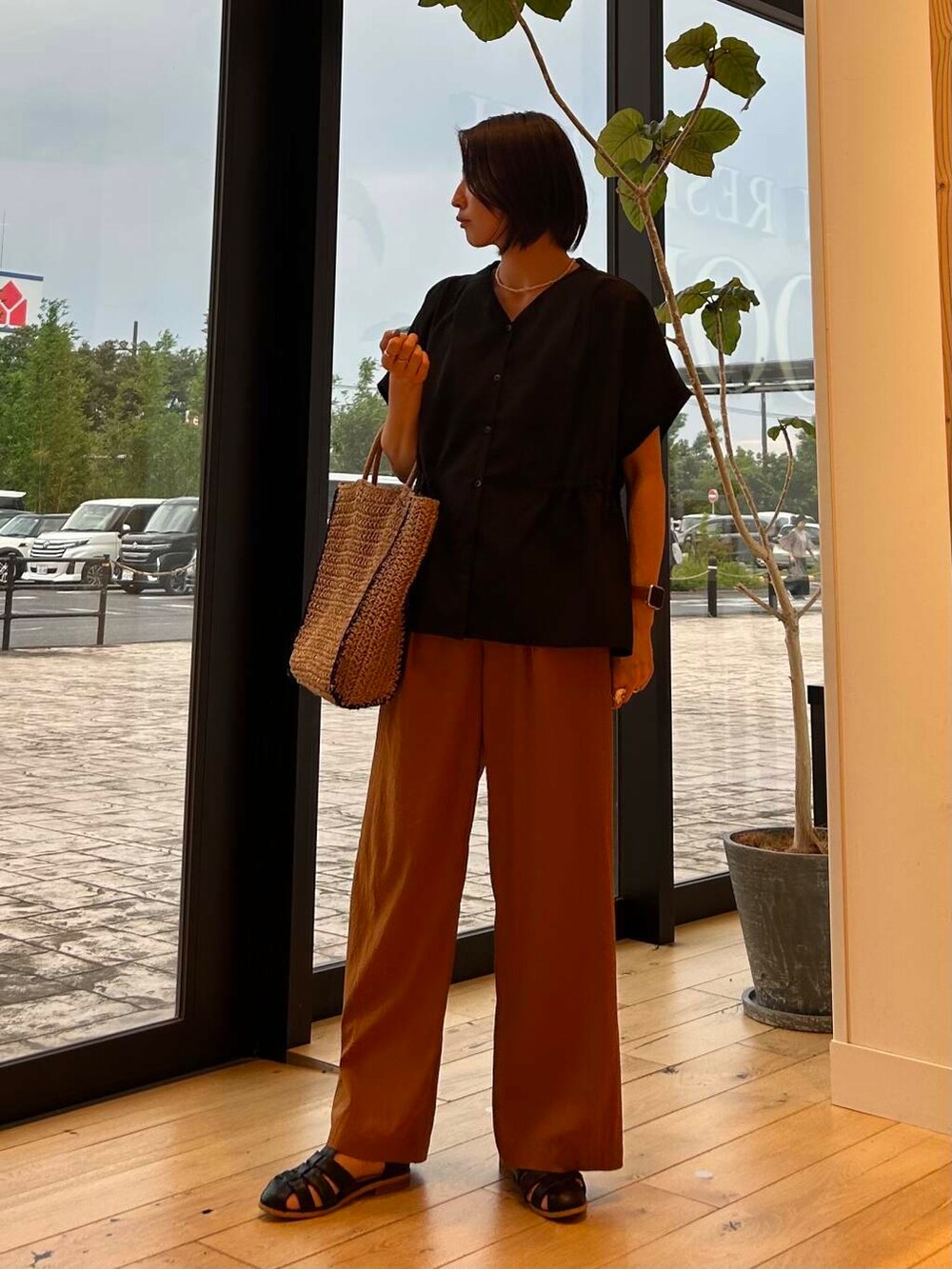 ベージュ系のトートバッグ、ベージュ系のタンクトップ、ブラック系のサンダルを着用したレディースの夏コーディネートの4枚目の写真