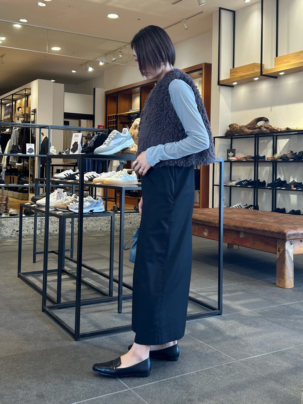 ブラック系のワンピース、ブルー系のショルダーバッグ、ブラック系のローファーを着用したレディースの秋コーディネートの4枚目の写真