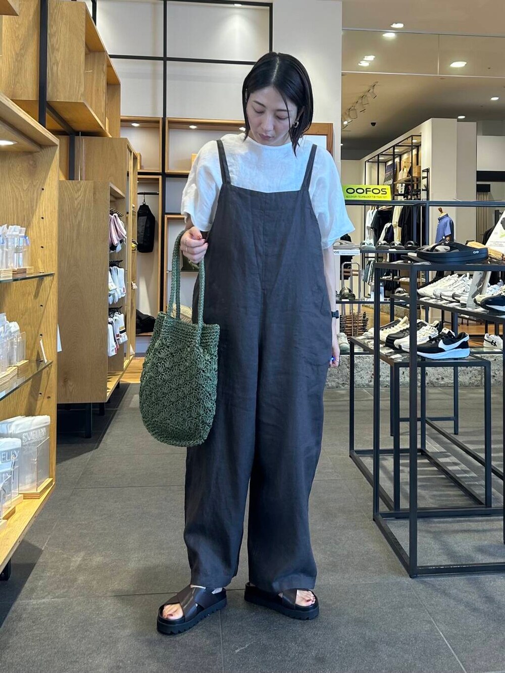 グリーン系のトートバッグ、グレー系のサロペット/オーバーオール、ブラウン系のサンダルを着用したレディースの夏コーディネートの2枚目の写真