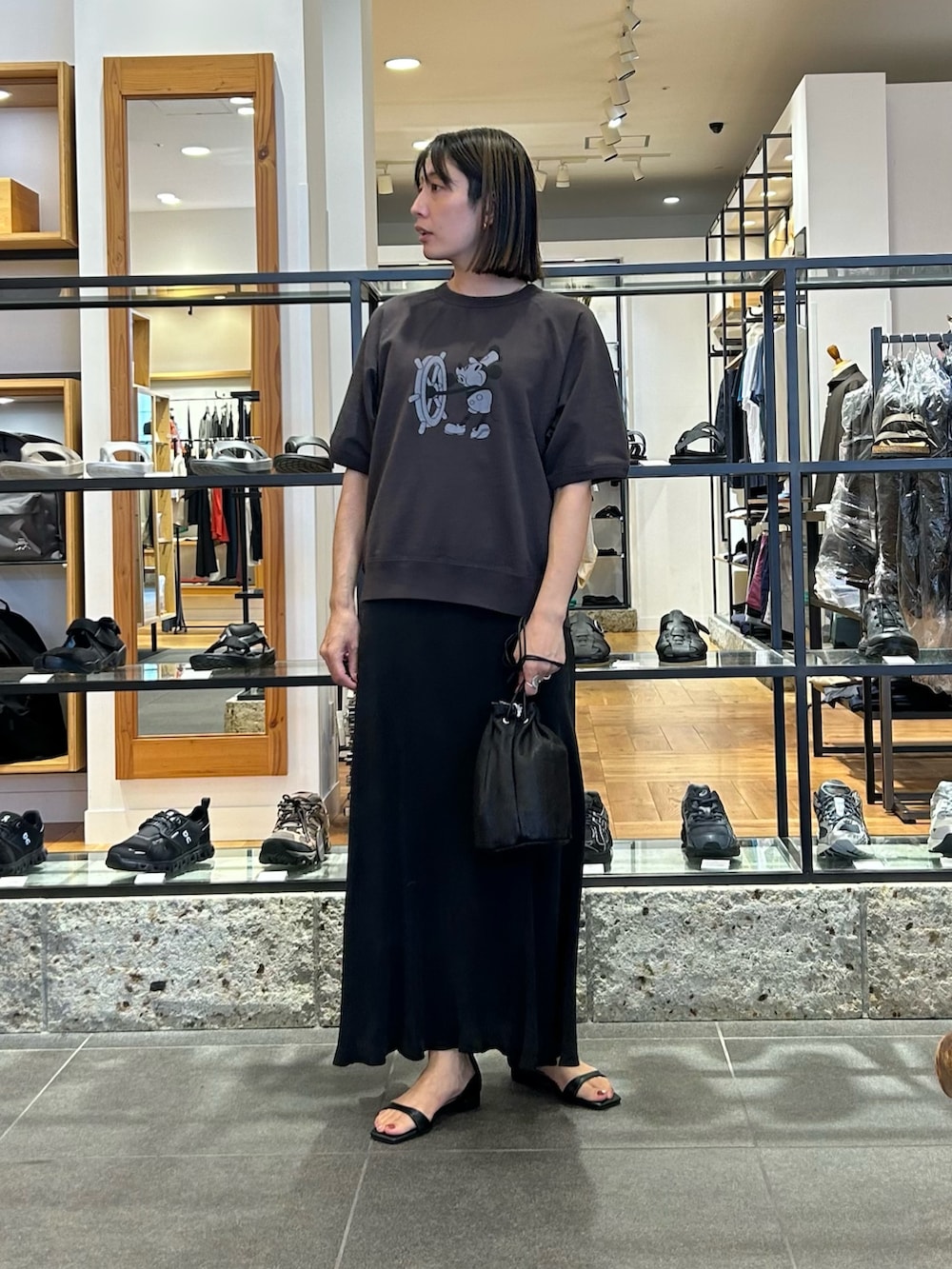 グレー系のシャツ/ブラウス、ブラック系のサンダル、ブラック系のスカートを着用したレディースの夏コーディネートの2枚目の写真