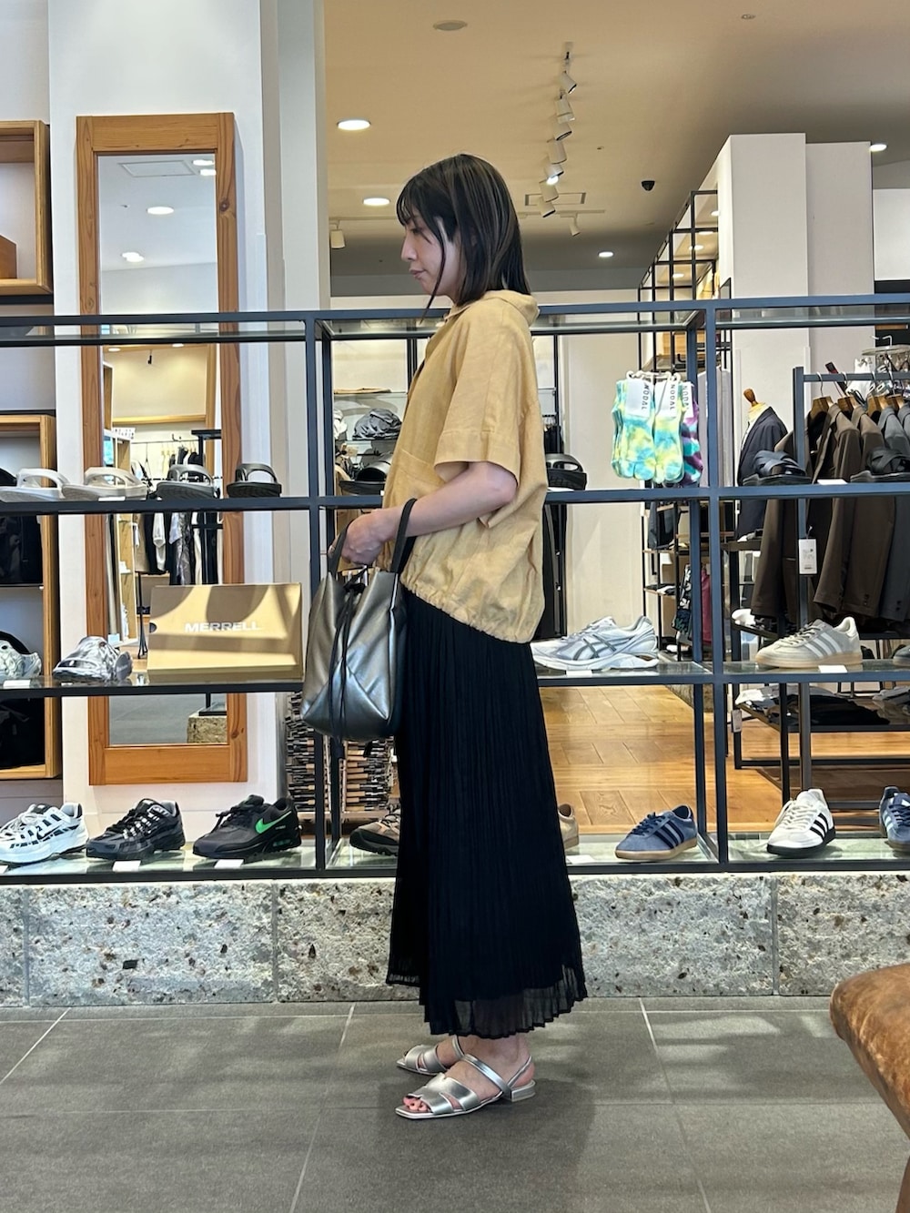 ブラック系のスカート、ベージュ系のシャツ/ブラウス、シルバー系のショルダーバッグを着用したレディースの夏コーディネートの5枚目の写真