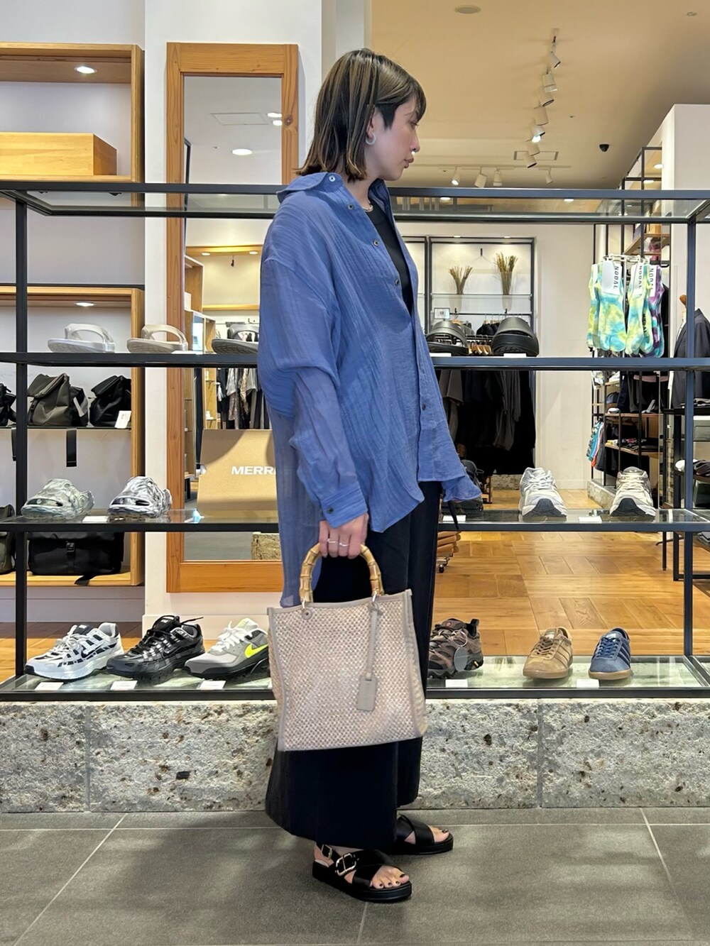 ブルー系のシャツ/ブラウス、ブラック系のタンクトップ、ブラック系のスカートを着用したレディースの春コーディネートの5枚目の写真