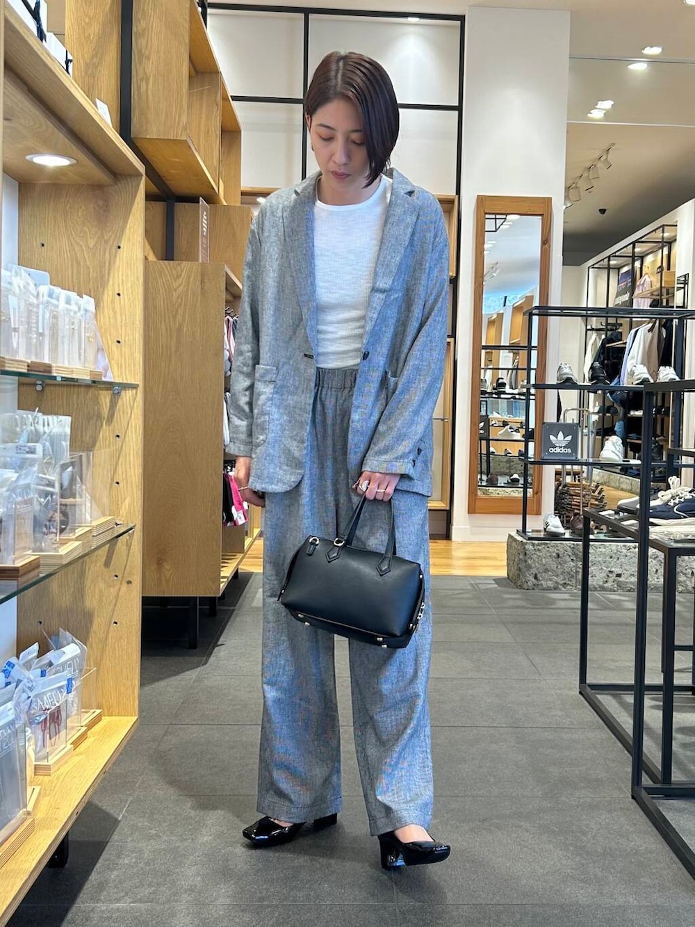 ホワイト系のTシャツ/カットソー、ブラック系のパンプス、ブラック系のトートバッグを着用したレディースの春コーディネートの2枚目の写真