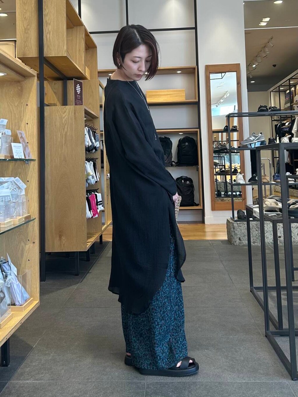 ベージュ系のタンクトップ、ベージュ系のトートバッグ、ブラック系のサンダルを着用したレディースの春コーディネートの3枚目の写真