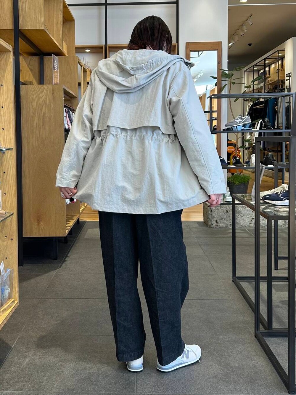 イエロー系のニット/セーター、グリーン系のハンドバッグ、ベージュ系のマウンテンパーカーを着用したレディースの春コーディネートの3枚目の写真