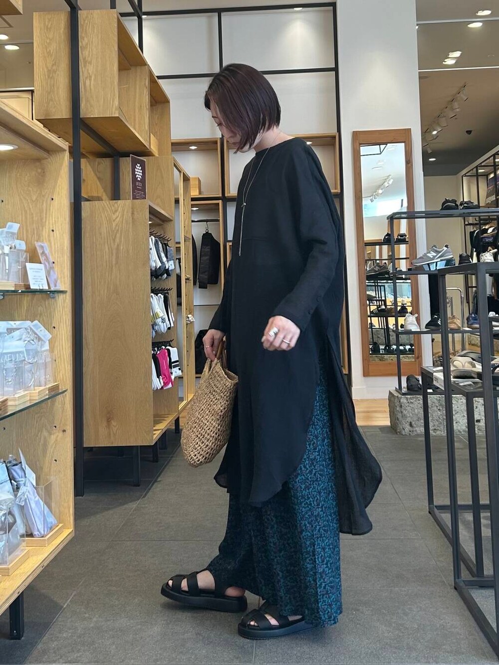 ベージュ系のタンクトップ、ベージュ系のトートバッグ、ブラック系のサンダルを着用したレディースの春コーディネートの5枚目の写真