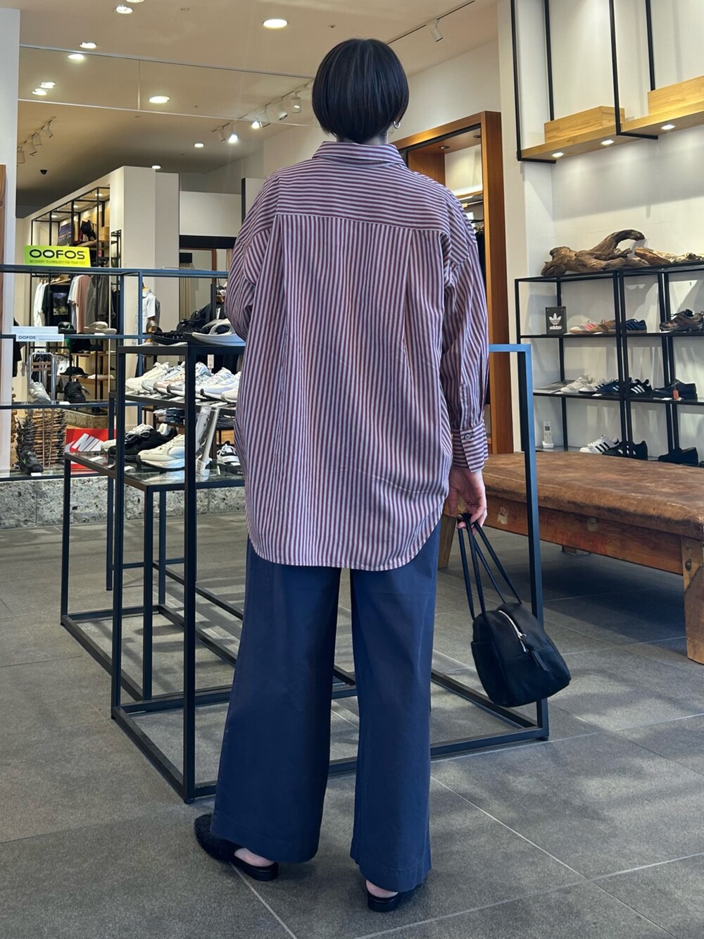 ブラック系のボストンバッグ、ブルー系のその他パンツ、レッド系のシャツ/ブラウスを着用したレディースの秋コーディネートの4枚目の写真