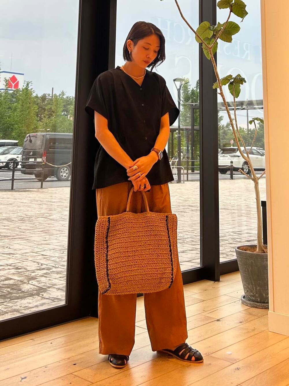 ベージュ系のトートバッグ、ベージュ系のタンクトップ、ブラック系のサンダルを着用したレディースの夏コーディネートの3枚目の写真