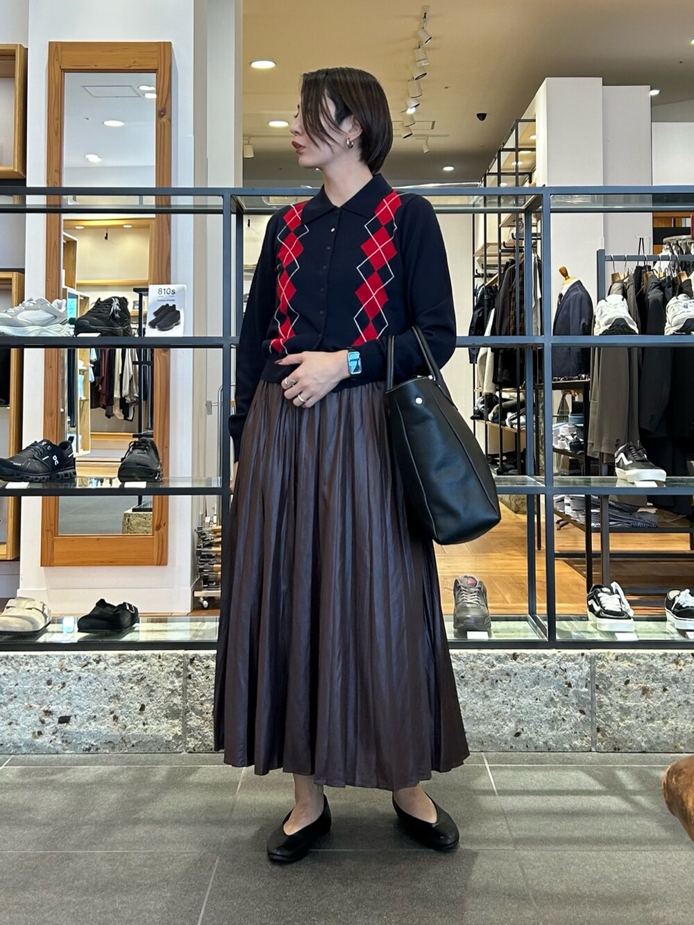 ブラウン系のスカート、ブルー系のニット/セーター、ブラック系のトートバッグを着用したレディースの秋コーディネートの3枚目の写真