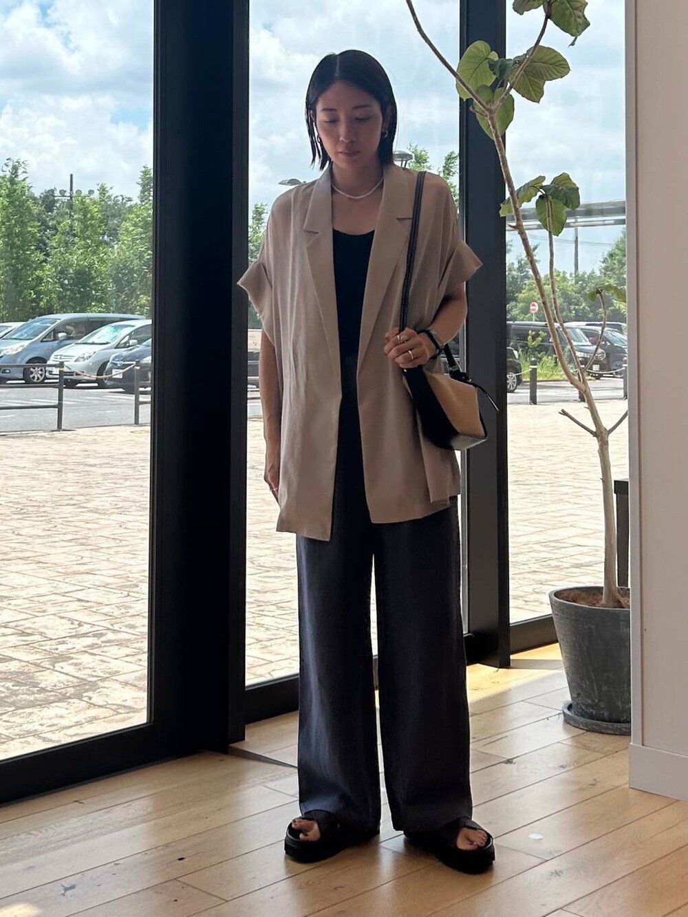 ブラック系のショルダーバッグ、ブラウン系のサンダル、ブルー系のその他パンツを着用したレディースの夏コーディネートの4枚目の写真