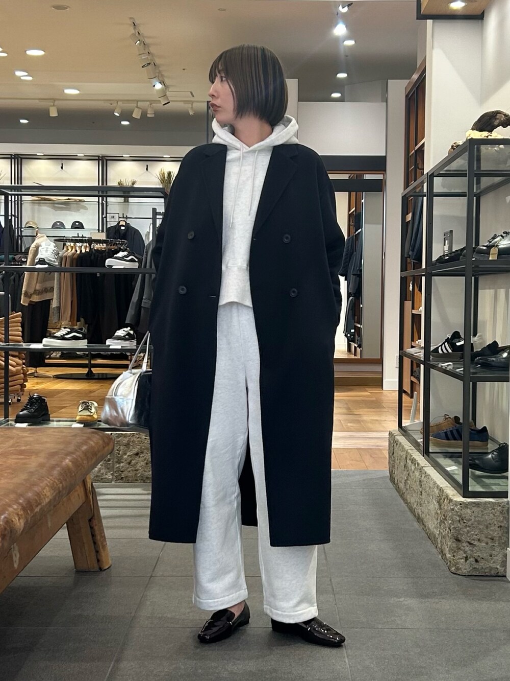 ベージュ系のパーカー、ブラウン系のローファー、シルバー系のボストンバッグを着用したレディースの冬コーディネートの3枚目の写真