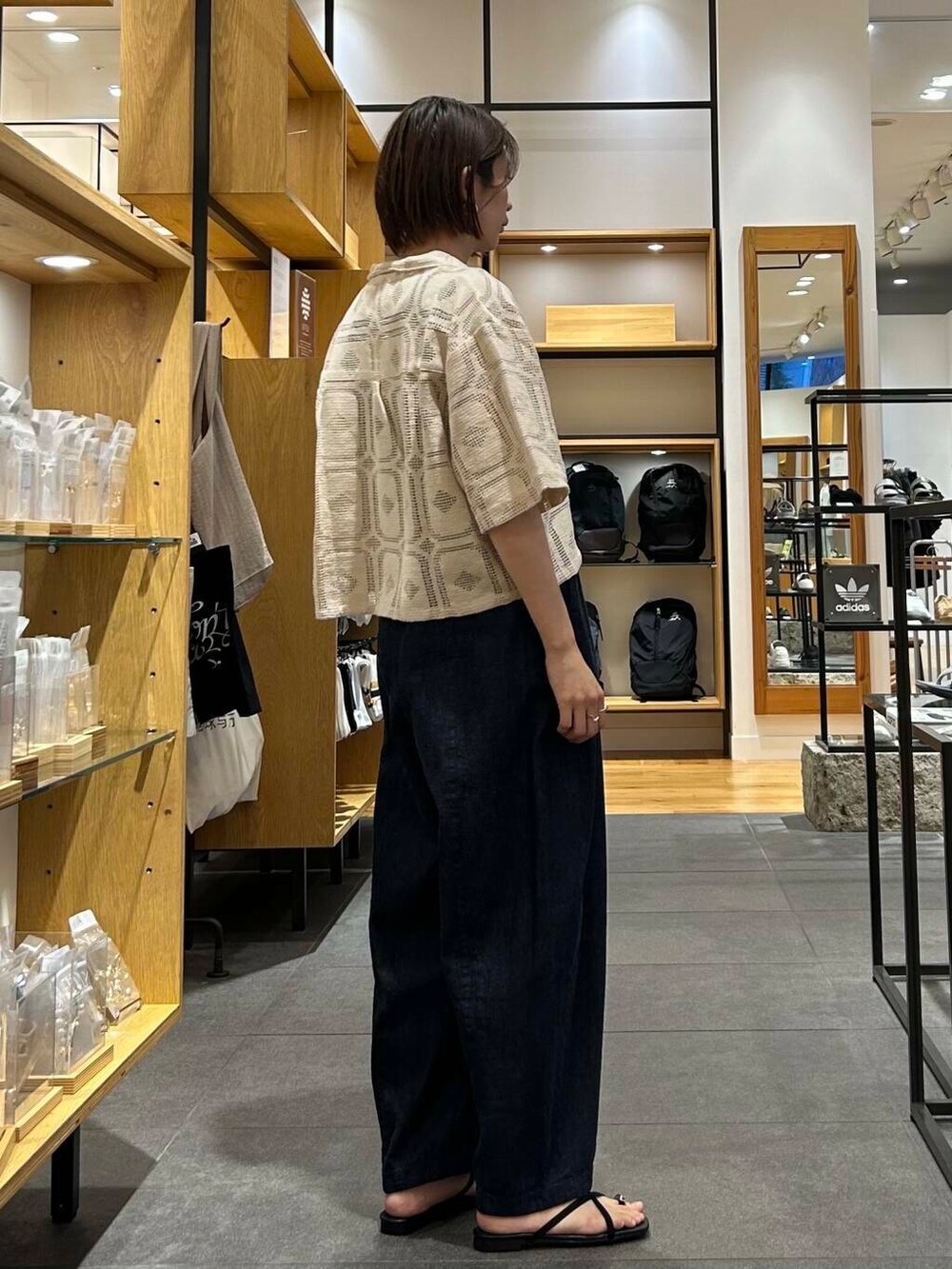 ブルー系のデニムパンツ、ブラック系のバックパック/リュック、ブラック系のタンクトップを着用したレディースの夏コーディネートの6枚目の写真