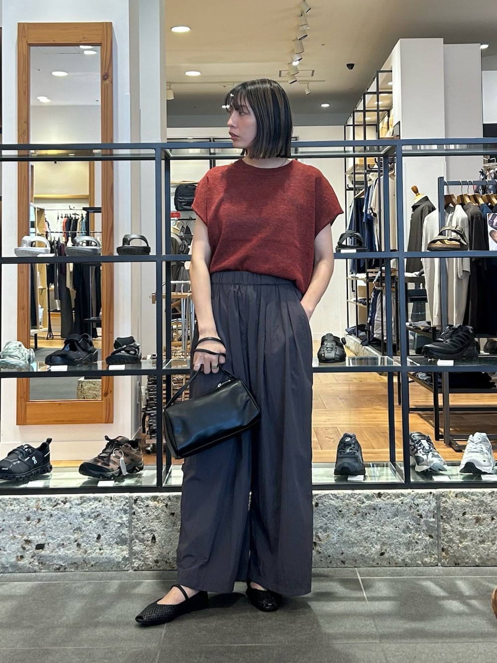 レッド系のその他トップス、グレー系のその他パンツ、ブラック系のハンドバッグを着用したレディースの夏コーディネートの5枚目の写真