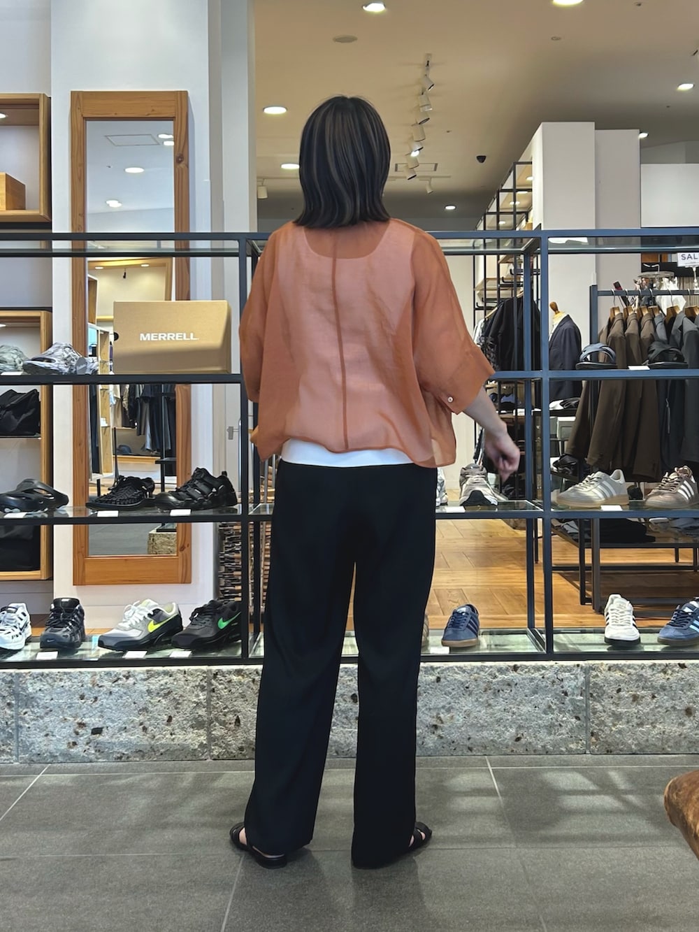 ブラック系のその他パンツ、ブラック系のサンダル、オレンジ系のショルダーバッグを着用したレディースの春コーディネートの5枚目の写真