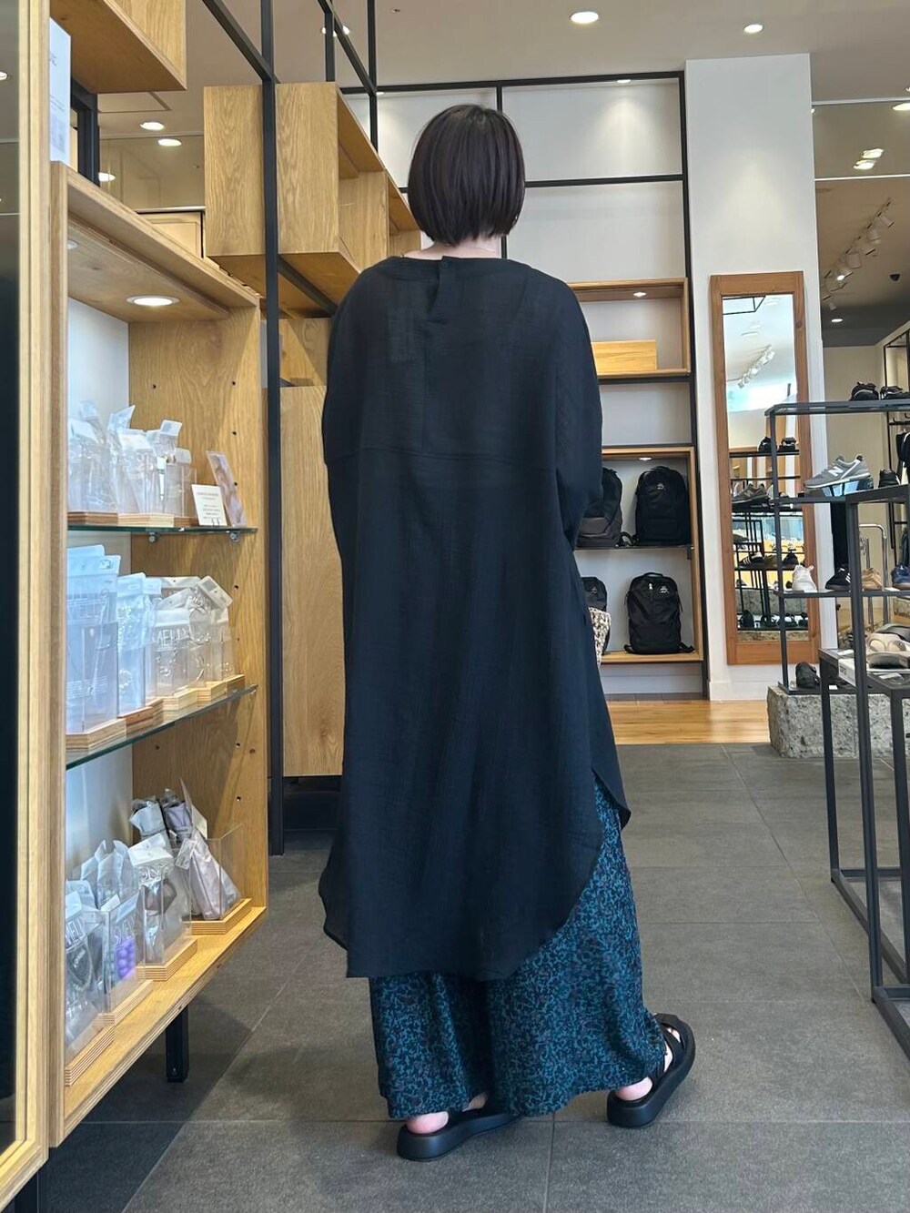 ベージュ系のタンクトップ、ベージュ系のトートバッグ、ブラック系のサンダルを着用したレディースの春コーディネートの6枚目の写真