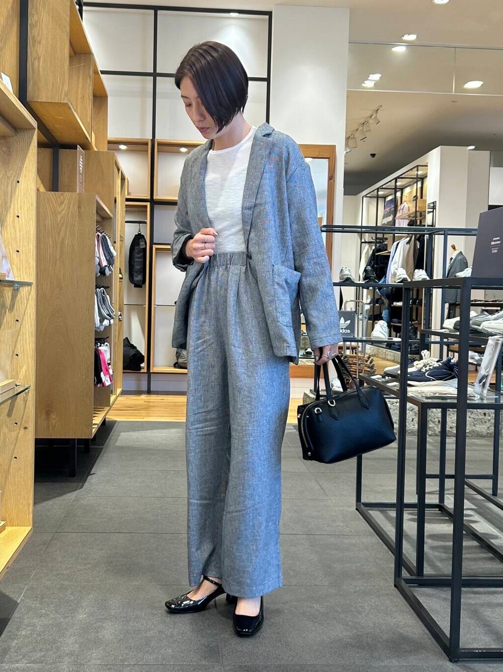 ホワイト系のTシャツ/カットソー、ブラック系のパンプス、ブラック系のトートバッグを着用したレディースの春コーディネートの4枚目の写真