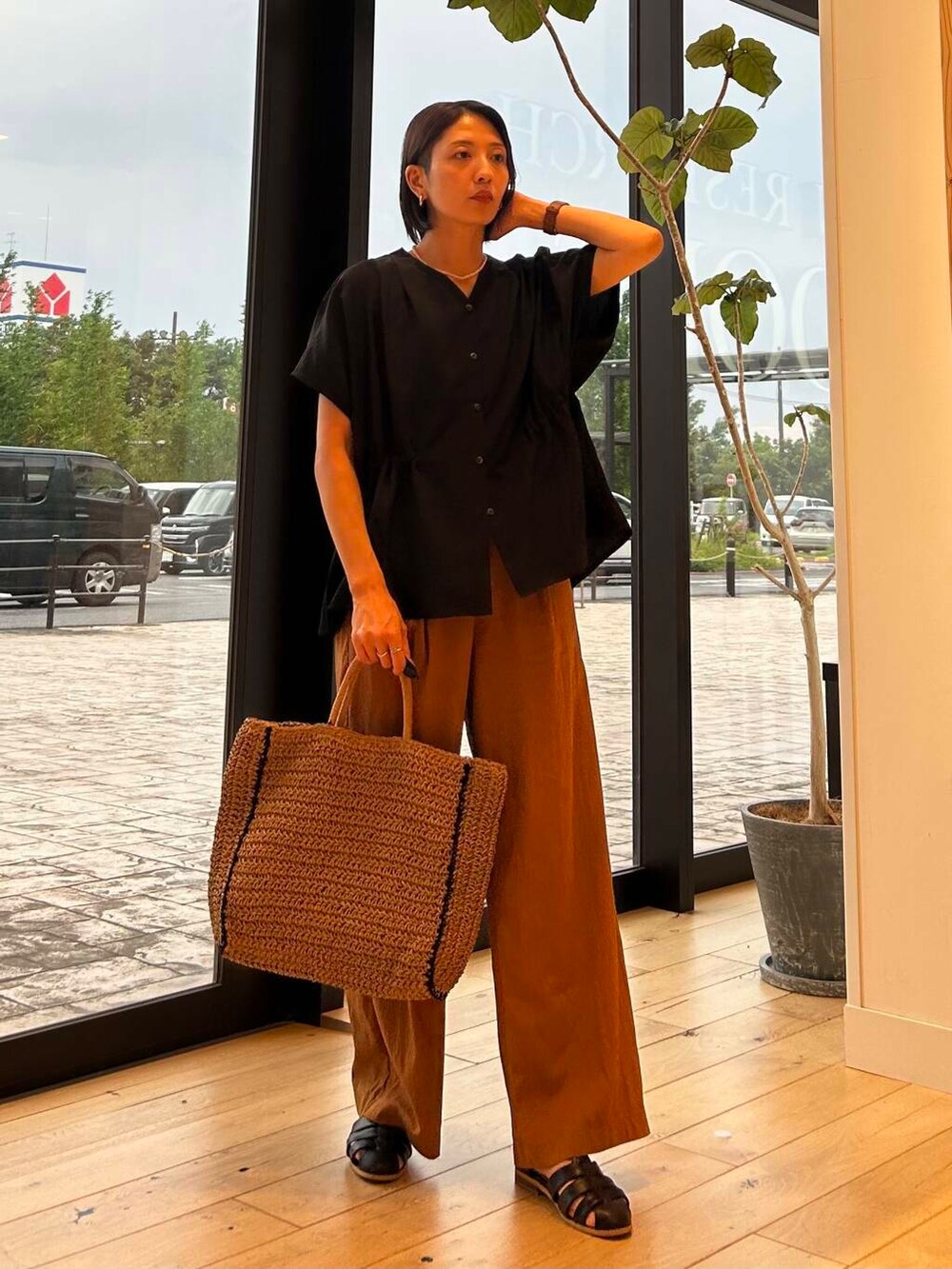 ベージュ系のトートバッグ、ベージュ系のタンクトップ、ブラック系のサンダルを着用したレディースの夏コーディネートの2枚目の写真