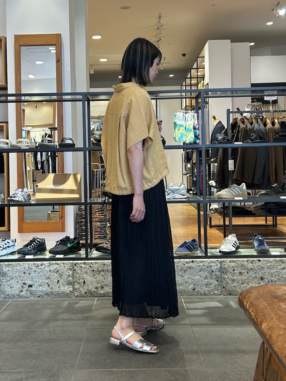 ブラック系のスカート、ベージュ系のシャツ/ブラウス、シルバー系のショルダーバッグを着用したレディースの夏コーディネートの3枚目の写真