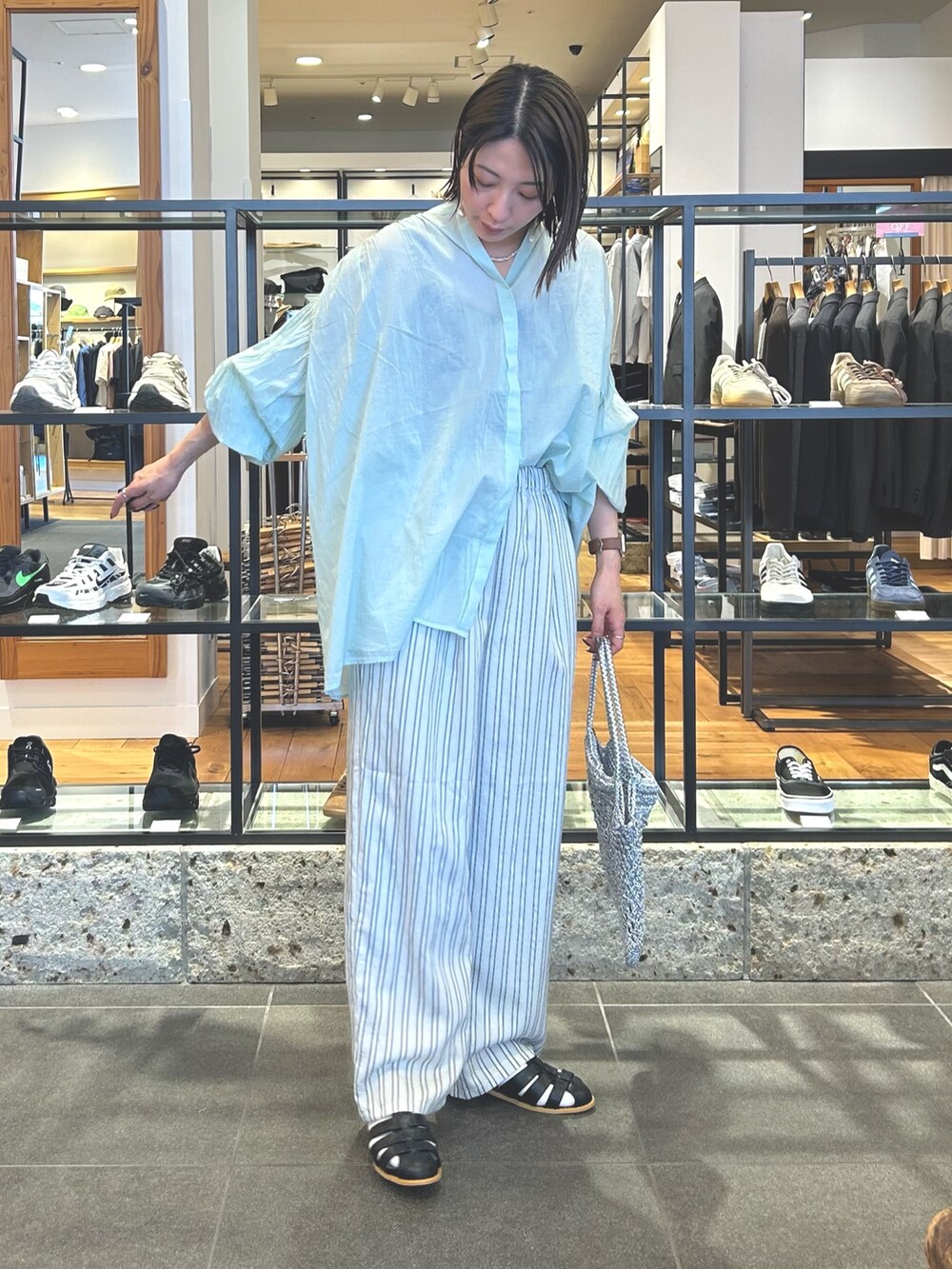 グレー系のその他パンツ、シルバー系のトートバッグ、ブラック系のサンダルを着用したレディースの春コーディネートの5枚目の写真