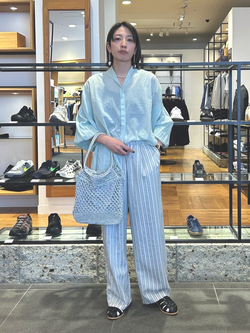 グレー系のその他パンツ、シルバー系のトートバッグ、ブラック系のサンダルを着用したレディースの春コーディネートの2枚目の写真