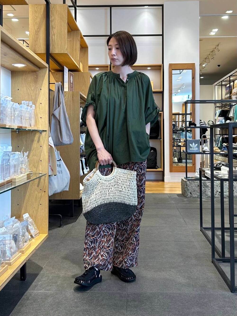 ベージュ系のトートバッグ、グリーン系のシャツ/ブラウス、ブルー系のその他パンツを着用したレディースの夏コーディネートの4枚目の写真