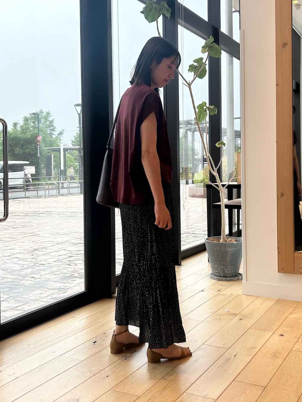 レッド系のTシャツ/カットソー、ブラック系のスカート、イエロー系のサンダルを着用したレディースの夏コーディネートの3枚目の写真