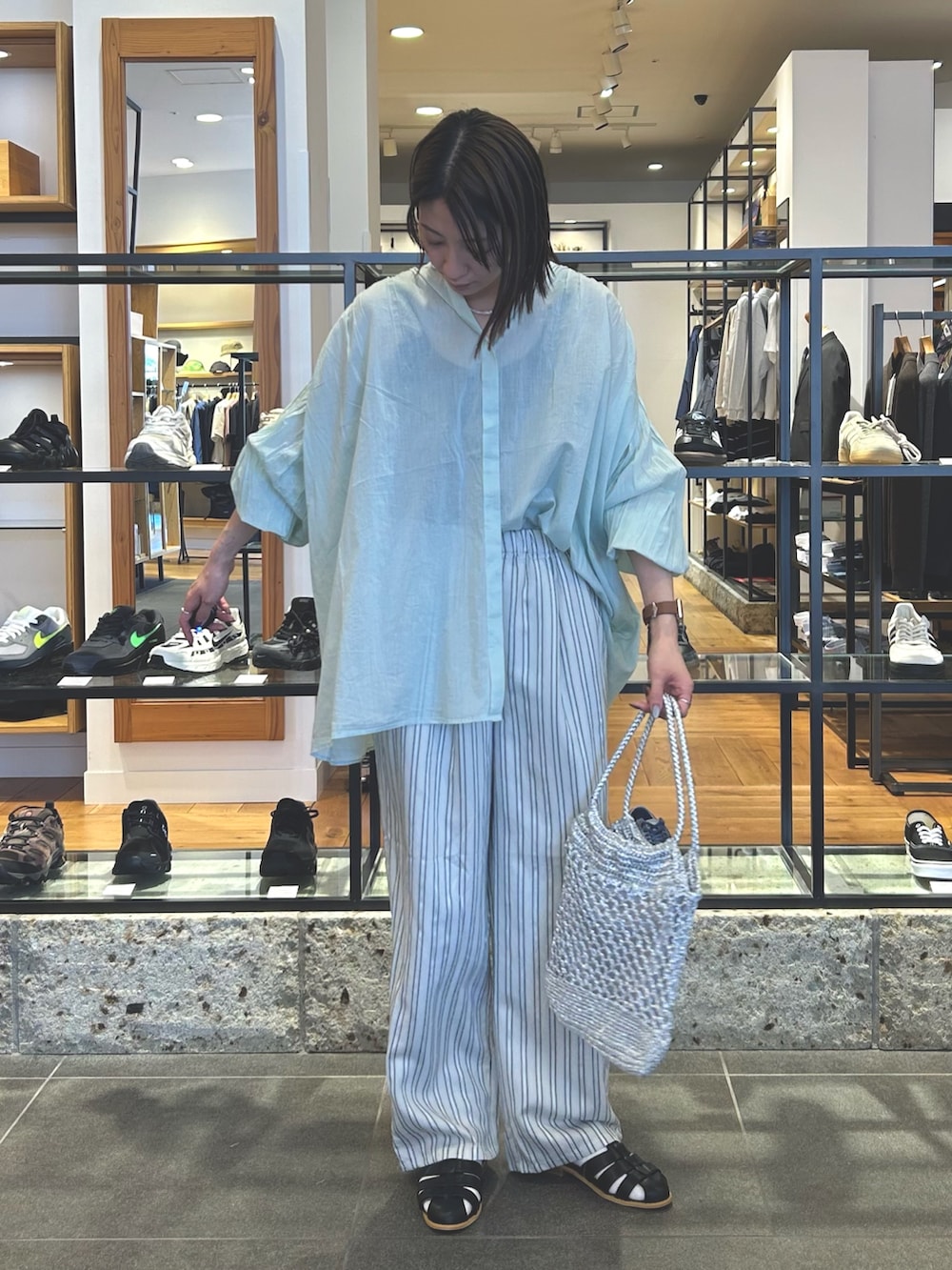 グレー系のその他パンツ、シルバー系のトートバッグ、ブラック系のサンダルを着用したレディースの春コーディネートの4枚目の写真