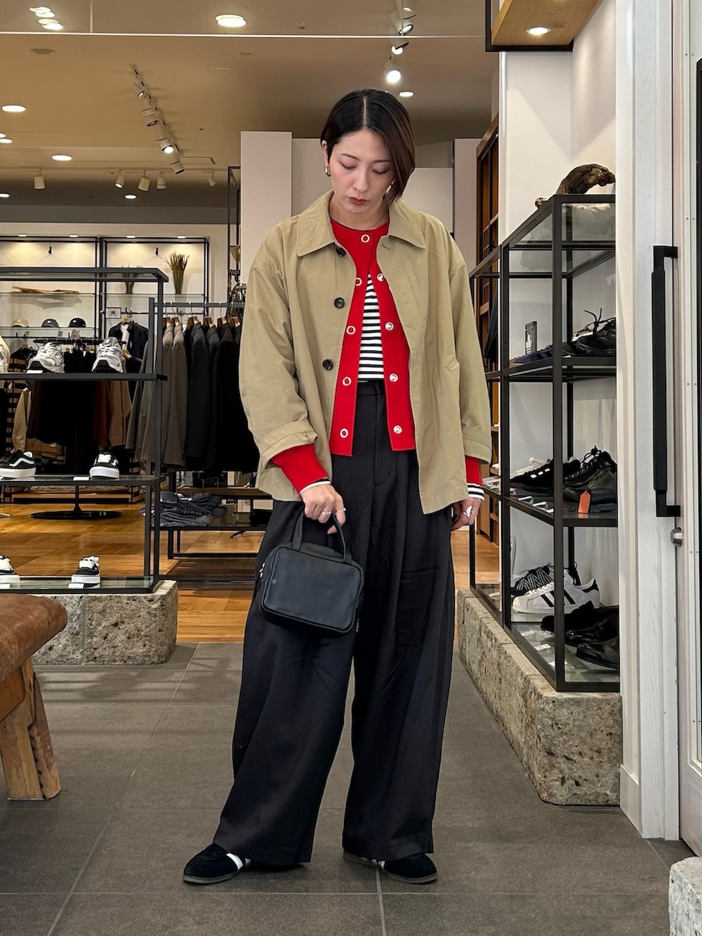 ブラック系のスニーカー、ブラック系のボストンバッグ、レッド系のカーディガン/ボレロを着用したレディースの秋コーディネートの2枚目の写真