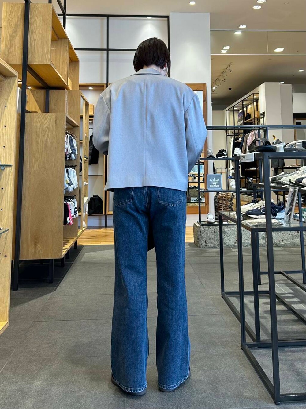 ブルー系のデニムパンツ、ブラック系のショルダーバッグ、グレー系のその他アウターを着用したレディースの春コーディネートの5枚目の写真