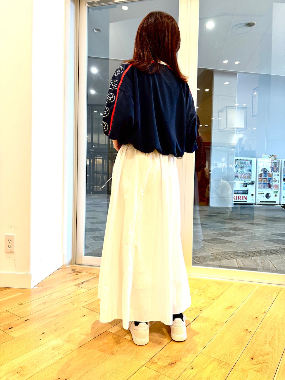 ホワイト系のスニーカー、ブルー系のTシャツ/カットソーを着用したレディースの春コーディネートの2枚目の写真