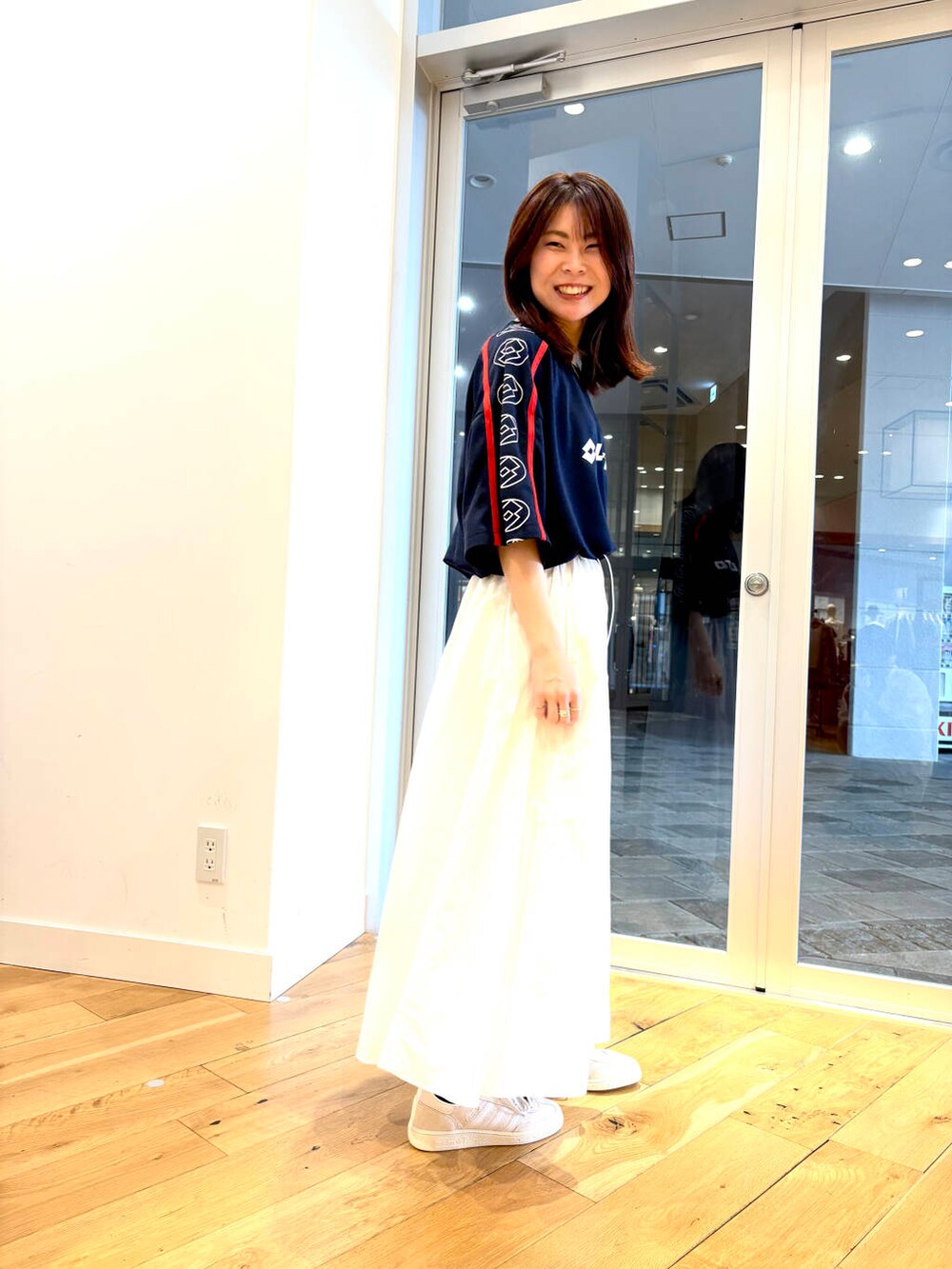 ホワイト系のスニーカー、ブルー系のTシャツ/カットソーを着用したレディースの春コーディネートの3枚目の写真