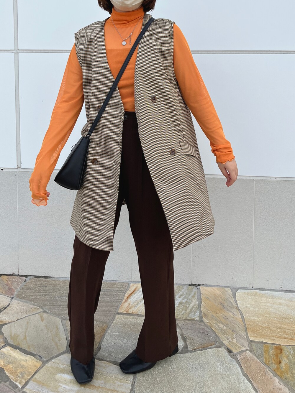 オレンジ系のその他トップス、その他のベストを着用したレディースの春コーディネートの2枚目の写真