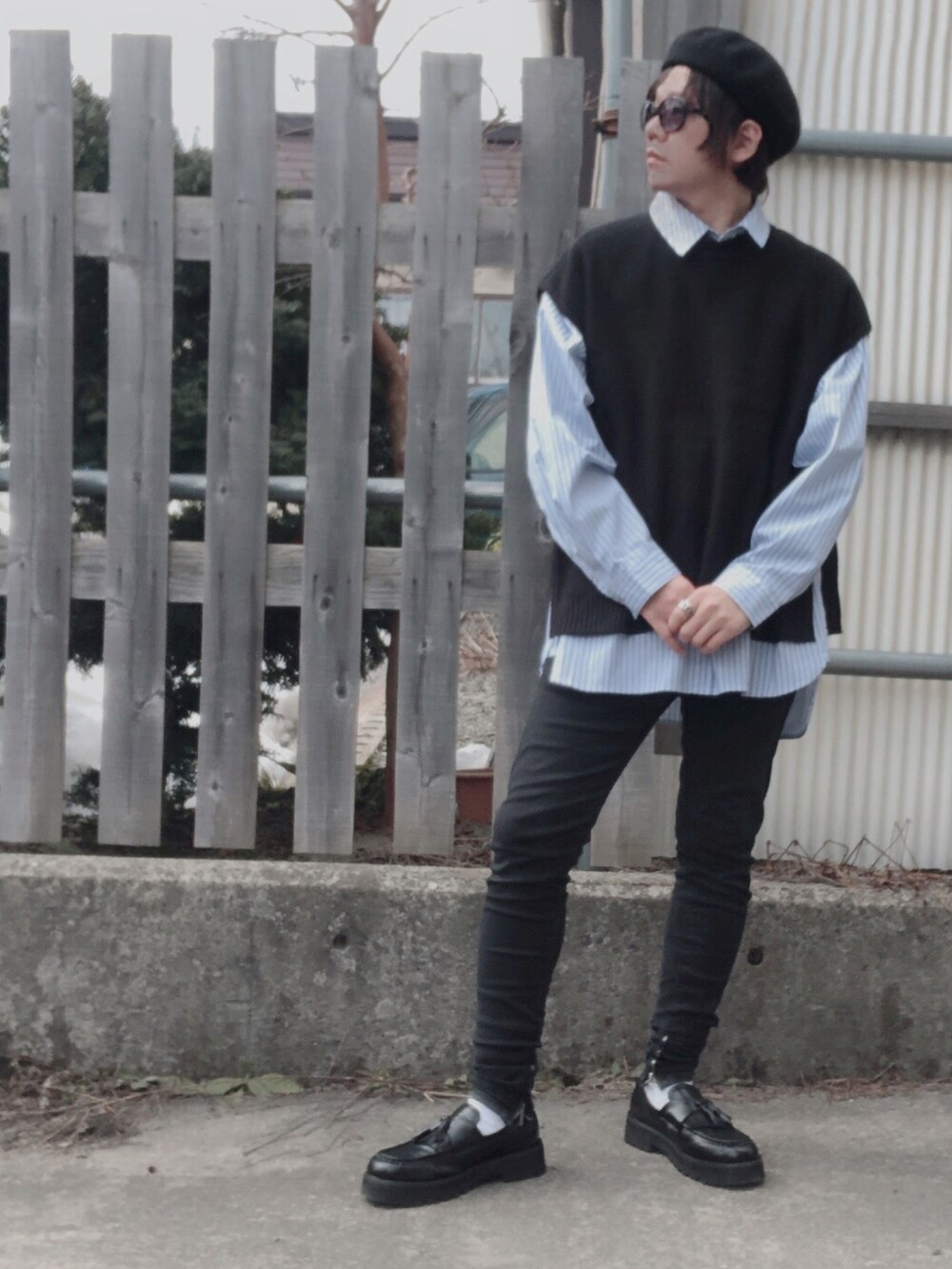 ブラック系のベスト、ブルー系のトップス、ブラック系のデニムパンツを着用したメンズの春コーディネートの2枚目の写真