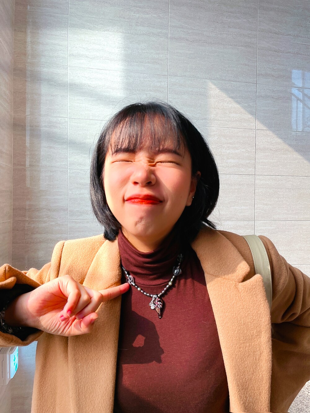 ベージュ系のシューズ、オレンジ系のチェスターコート、ホワイト系のチノパンツを着用したレディースの秋コーディネートの2枚目の写真