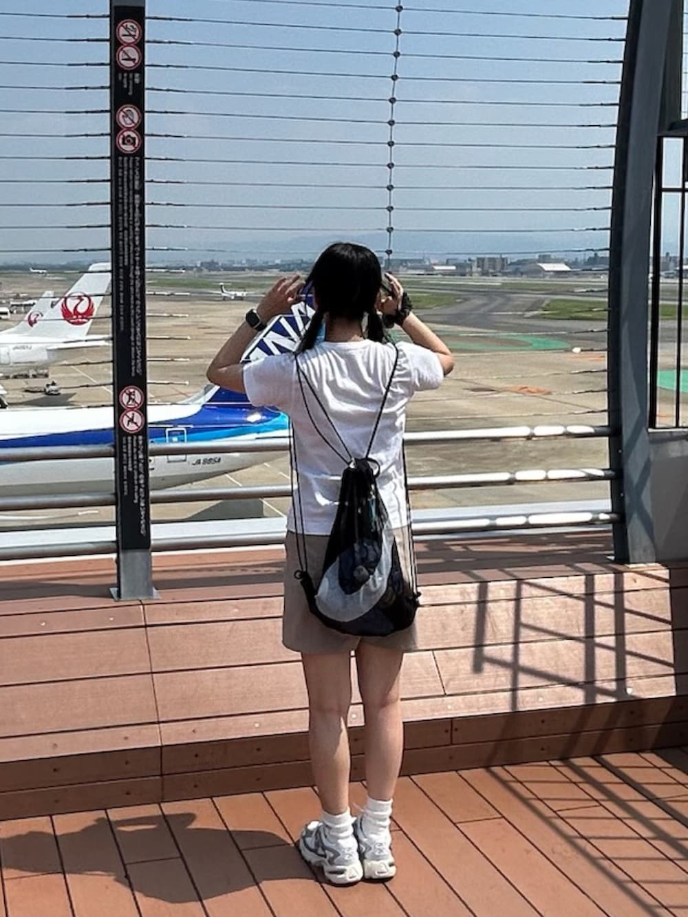 シルバー系のスニーカー、ホワイト系のTシャツ/カットソー、ベージュ系のカーゴパンツを着用したレディースの夏コーディネートの2枚目の写真