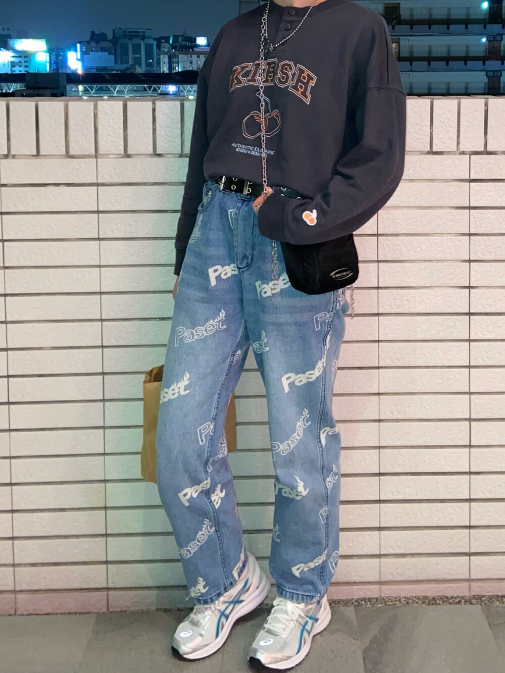 グレー系のスウェット、ブラック系のバッグ、ブルー系のデニムパンツを着用したレディースの冬コーディネートの2枚目の写真