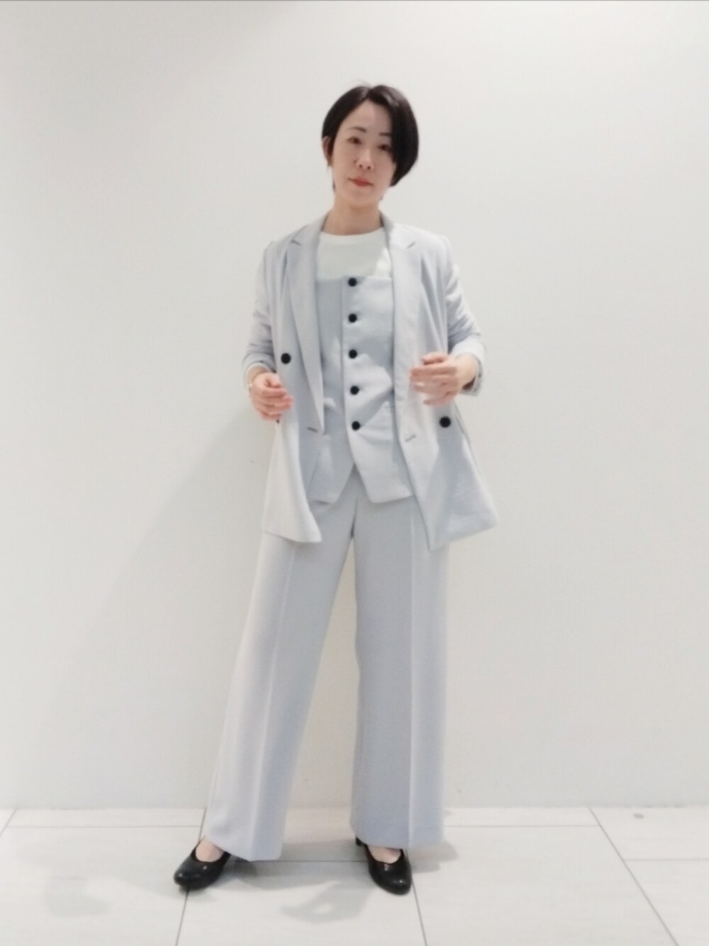 ホワイト系のTシャツ/カットソー、グレー系のタンクトップ、グレー系のスーツジャケットを着用したレディースの春コーディネートの3枚目の写真