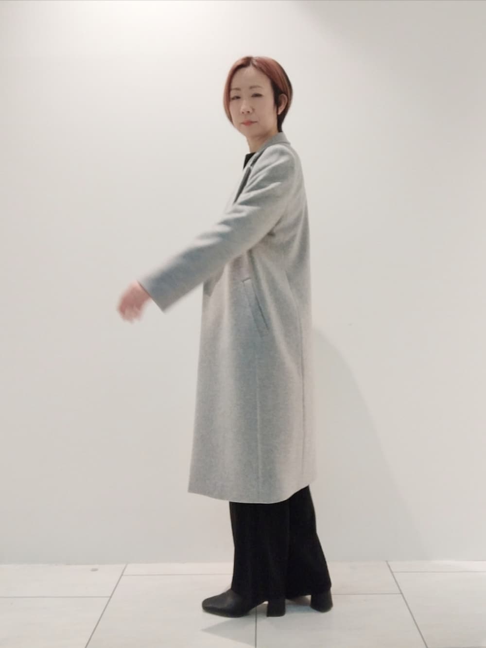 グレー系のチェスターコート、ブラック系のシャツ/ブラウス、ブラック系のスーツパンツを着用したレディースの冬コーディネートの4枚目の写真