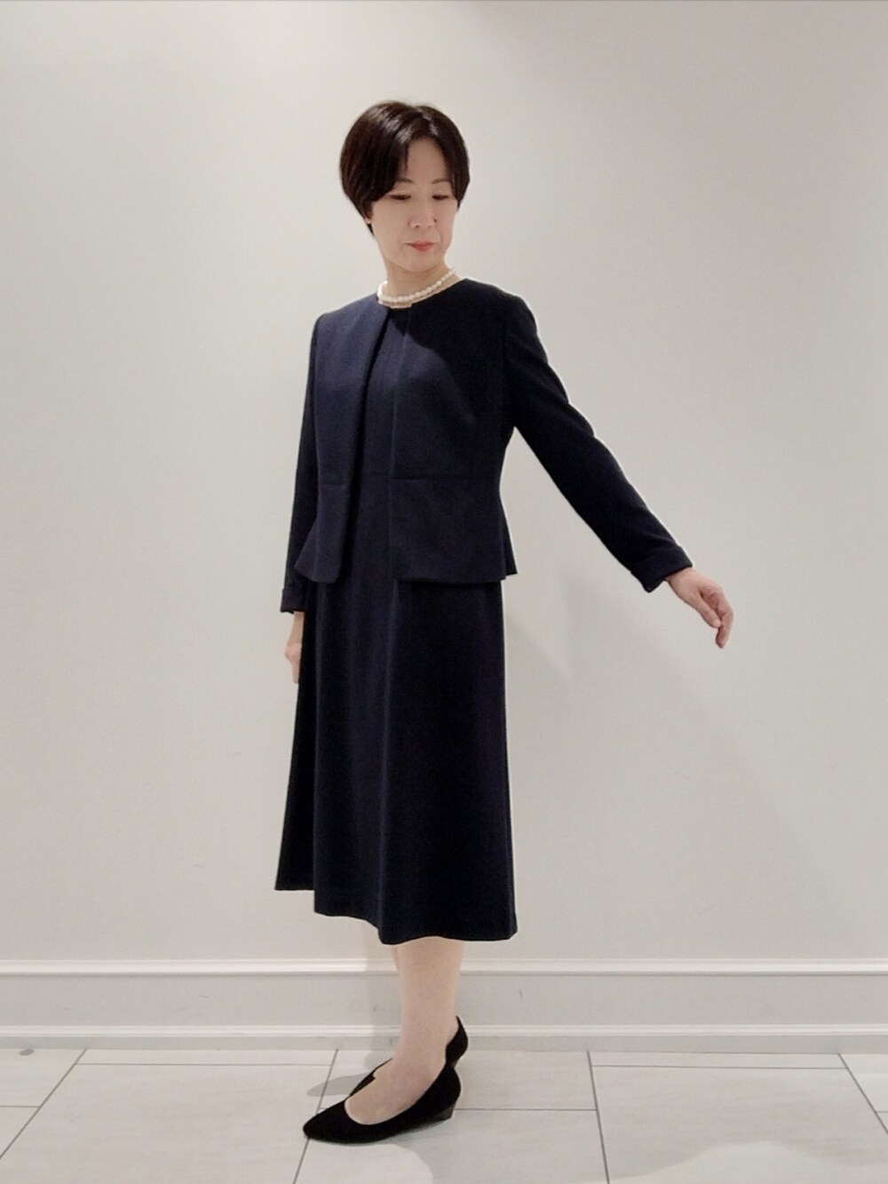 ブラック系のスーツジャケット、ブルー系のワンピース、その他のその他を着用したレディースの秋コーディネートの3枚目の写真