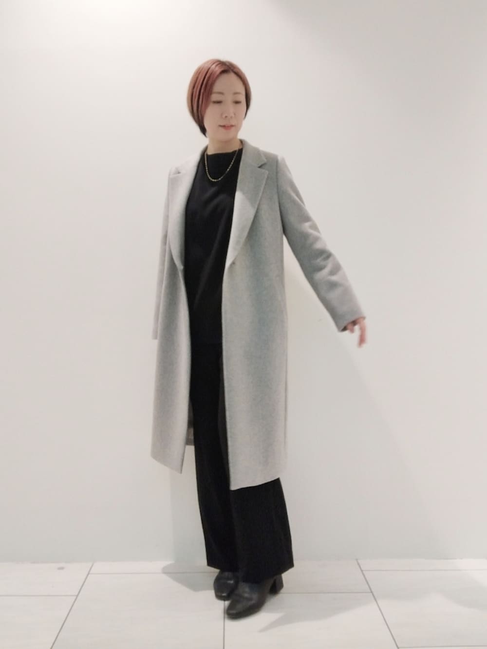 グレー系のチェスターコート、ブラック系のシャツ/ブラウス、ブラック系のスーツパンツを着用したレディースの冬コーディネートの3枚目の写真